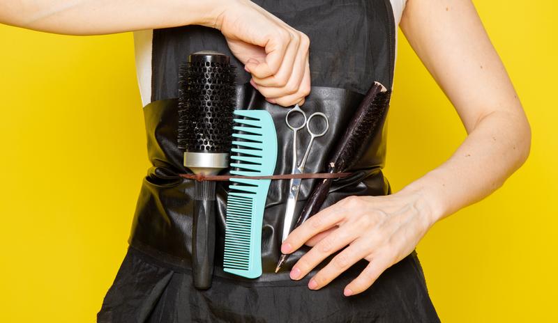 Bitrix 183734: front_view_young_female_hairdresser_white_t_shirt_black_cape_taking_scissors_with_brushes_wave_hair.jpg