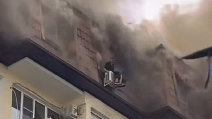 Спасение из огня женщины, сидевшей на кондиционере в горящем доме Сочи, сняли на видео